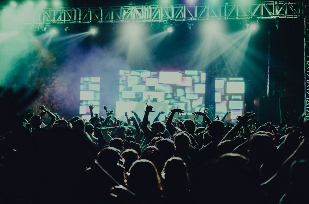 Crowd at a live concert with colorful stage lights